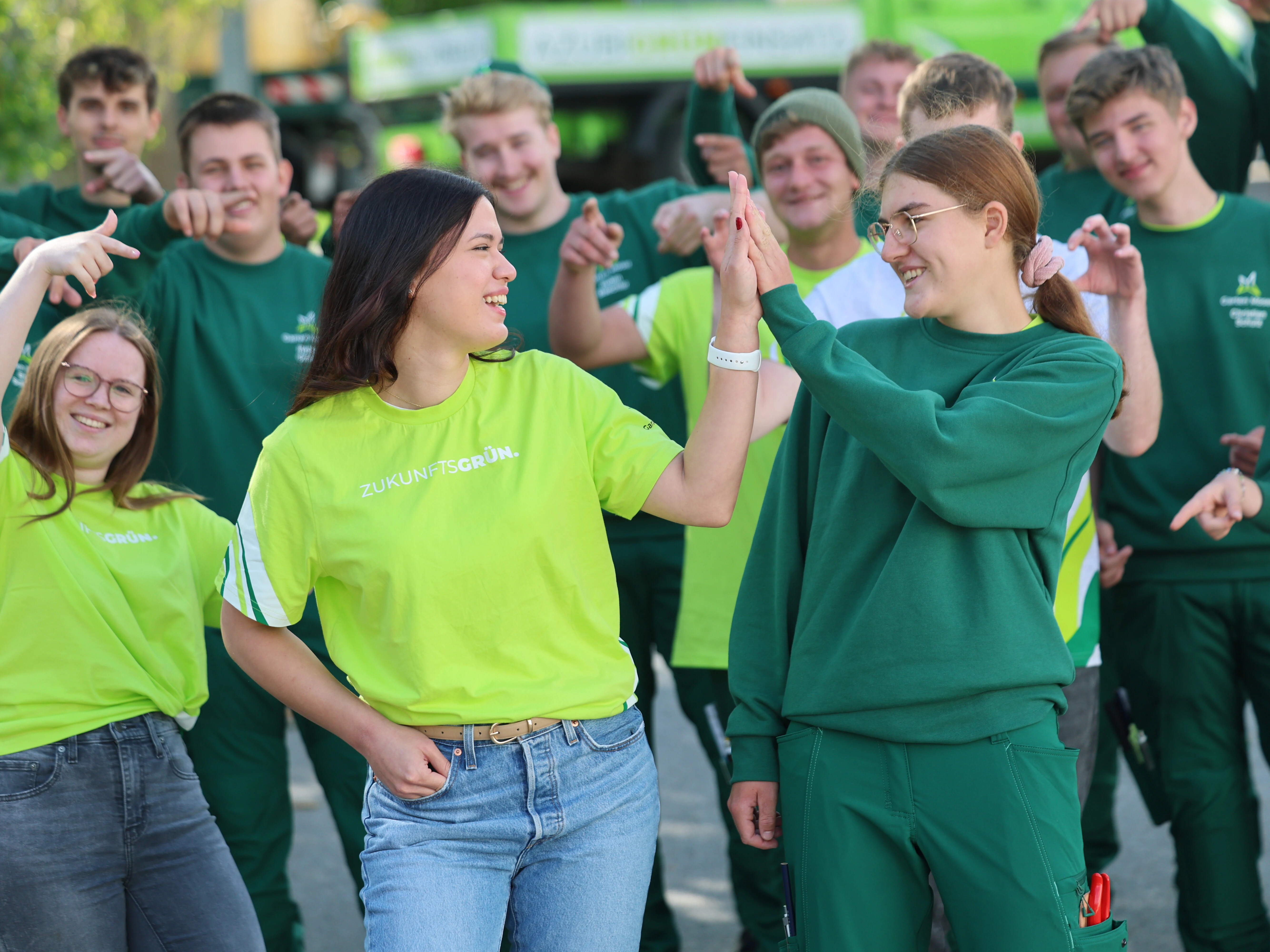 Zwei Garten-Moser-Mitarbeitende geben sich ein High-Five auf der Baustelle – sichtbare Freude und Teamzusammenhalt