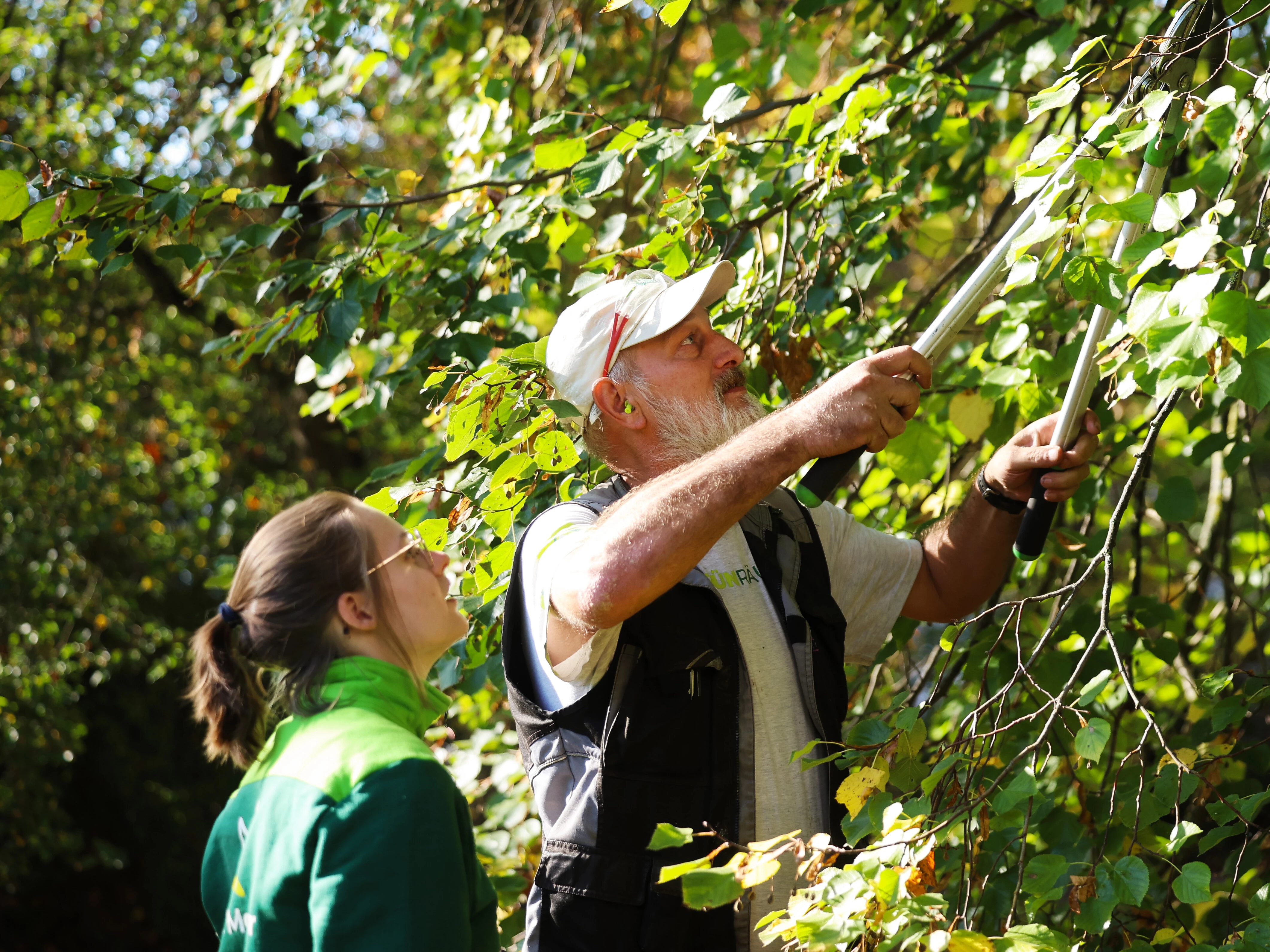 Sechs Mitarbeitende von Garten Moser posieren lachend auf einem frisch verlegten Kunstrasenplatz